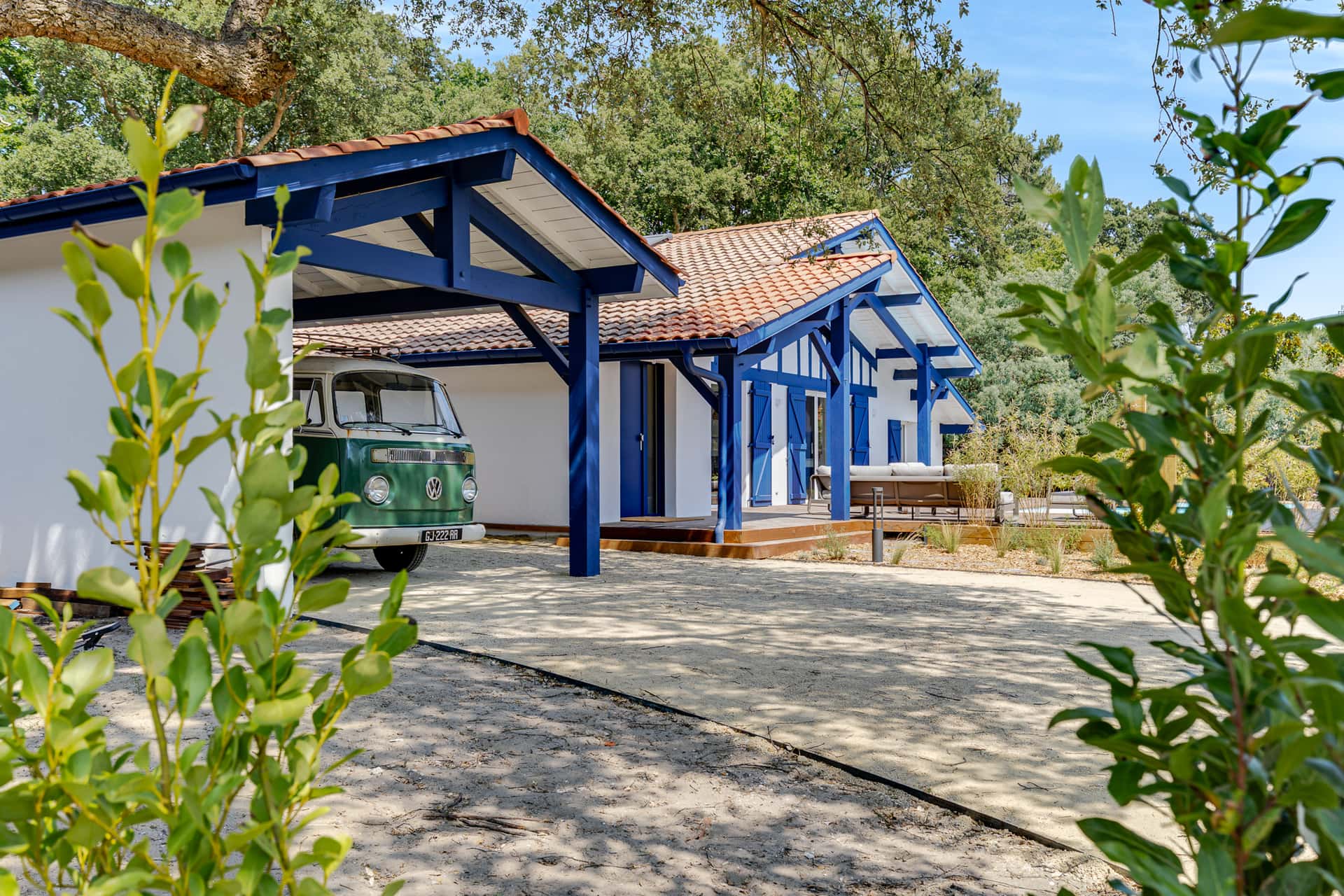 Villa basco-landaise aux volets bleus et son combi Volkswagen vert sous le carport, une location Green Coast à Capbreton